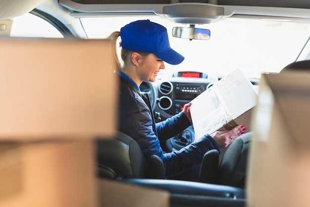 Woman with packed box in car