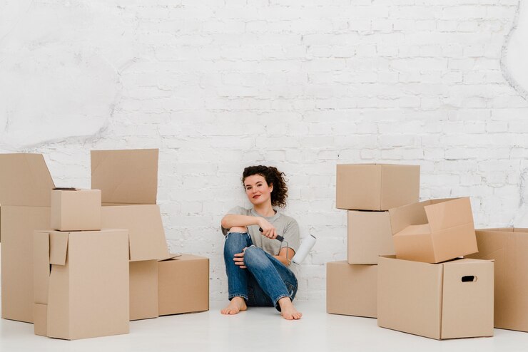 Free Photo woman with paint roller near boxes