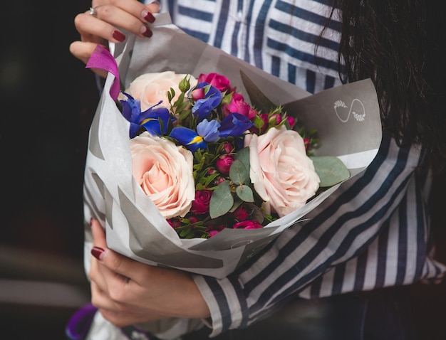 色とりどりの花の紙の花束を持つ女性