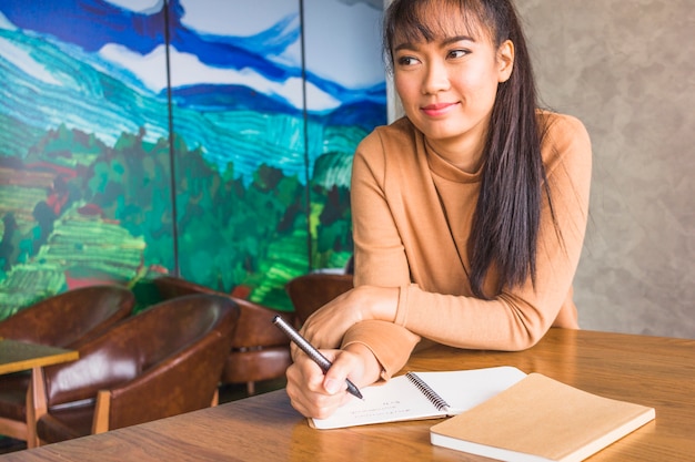 Free photo woman with pen and notebooks