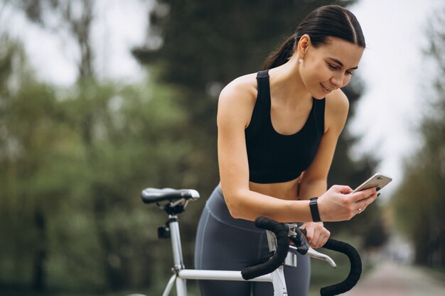 Woman with phone bicycling