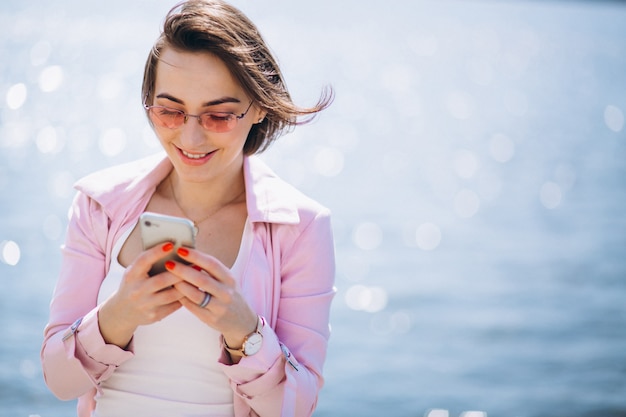 Free photo woman with phone by ocean