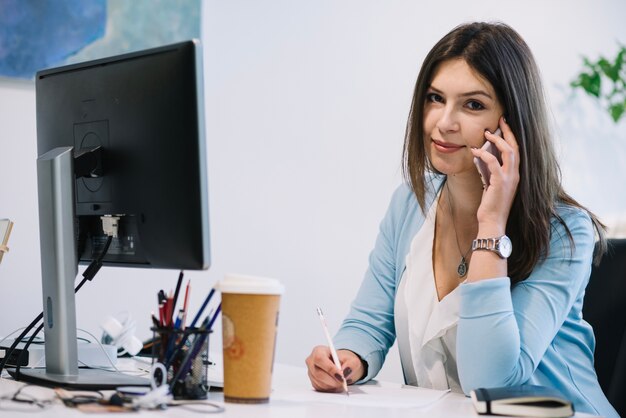 Woman with phone and looking at camera