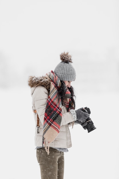Бесплатное фото Женщина с фото камерой зимой