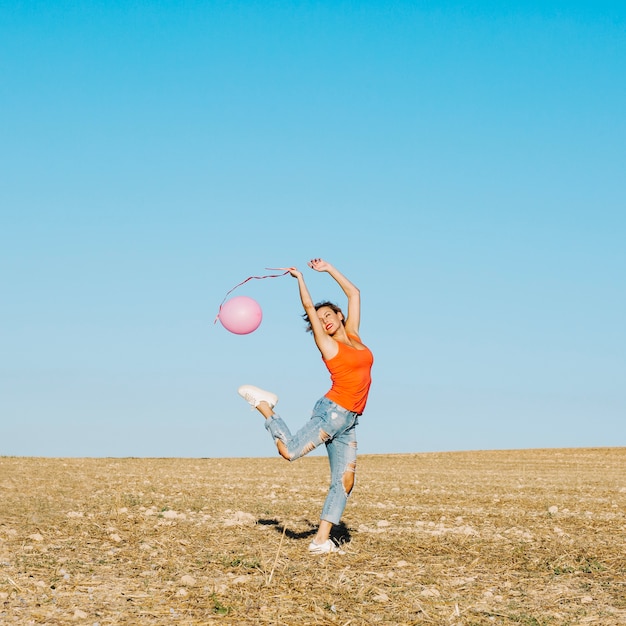 Woman with pink balloon in nature