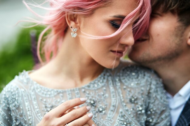 Woman with pink hair leans to her man tender