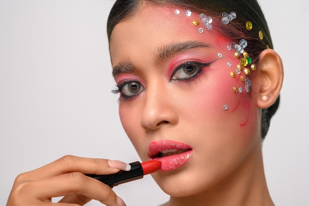 A woman with pink makeup and lipstick on her lips isolated on white