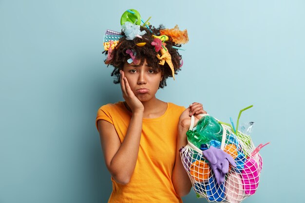 Foto gratuita donna con rifiuti di plastica in borsa a rete