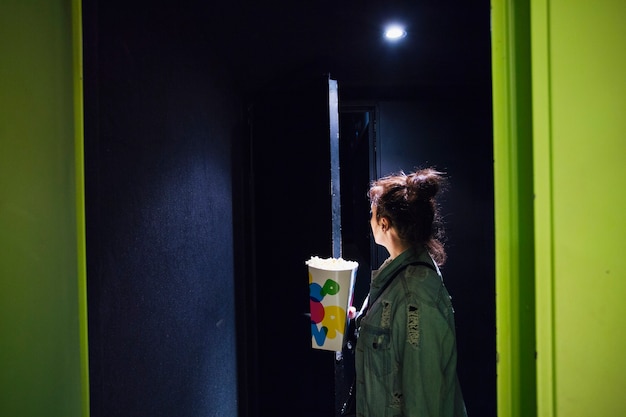 Woman with popcorn in cinema theatre