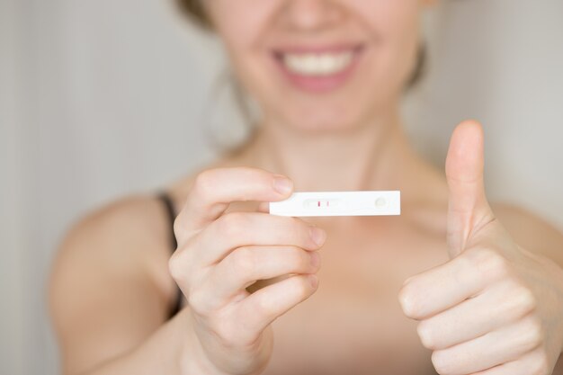 Женщина с положительным тестом на беременность