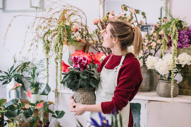 店で鉢植えの花を持つ女性