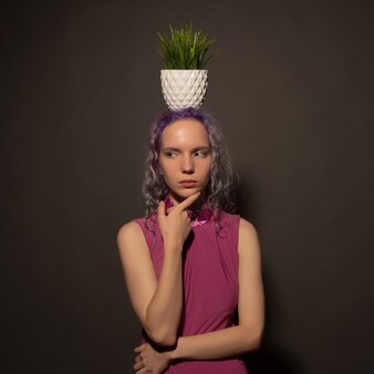 Woman with a potted plant on her head. trying to hide from psychological problems