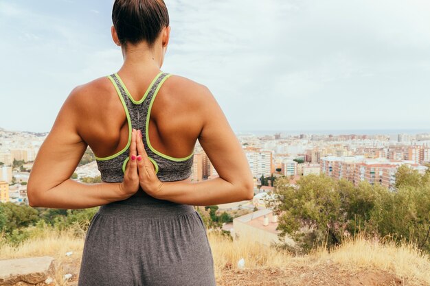 Woman with praying hands at her back