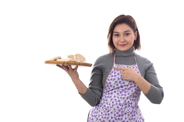 Woman with purple apron holding cookies