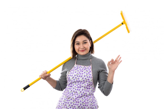 Free photo woman with purple apron and a mop