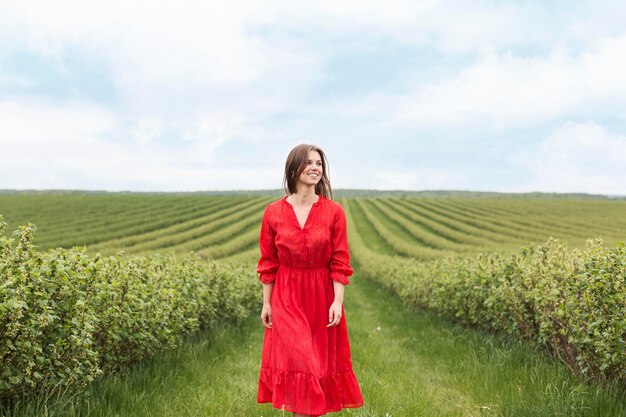 Woman with red dress in field