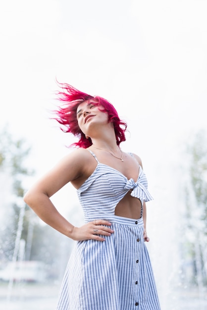 Woman with red hair and water fountain behind