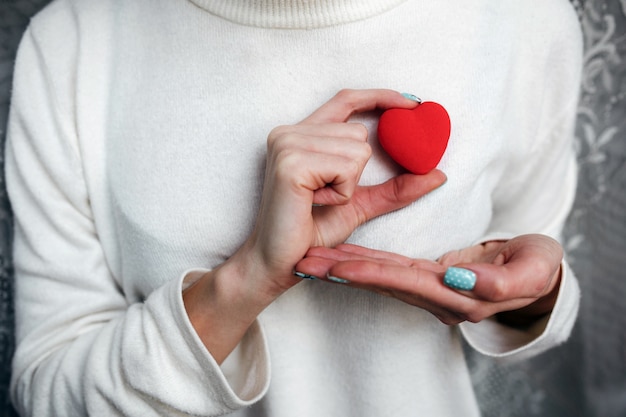 La donna con un cuore rosso in mano