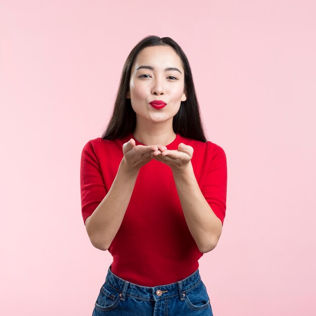 Woman with red lips blowing kiss