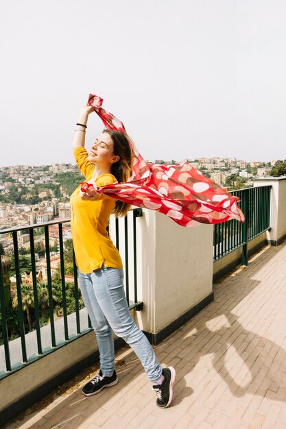Woman with red scarf enjoying wind