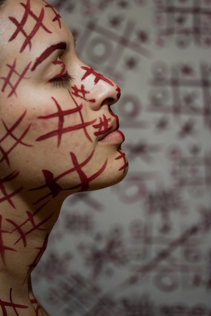 Woman with red symbols painted on the face