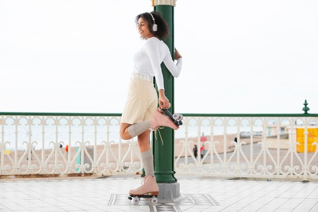 Woman with roller skates listening to music outdoors