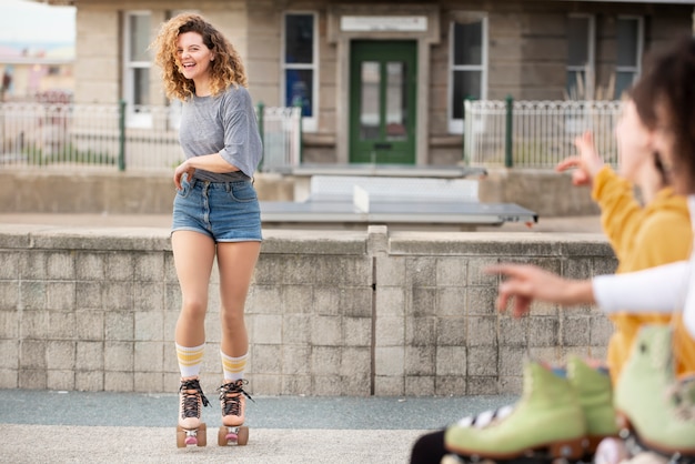 롤러 스케이트를 탄 여자가 야외에서 친구들과 함께 웃고