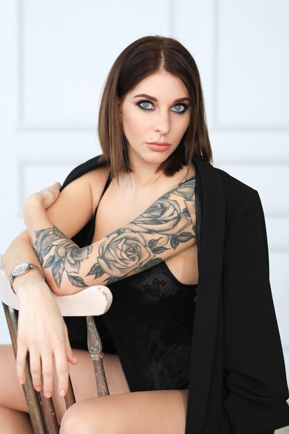 Woman with rose tattoo in black lingerie