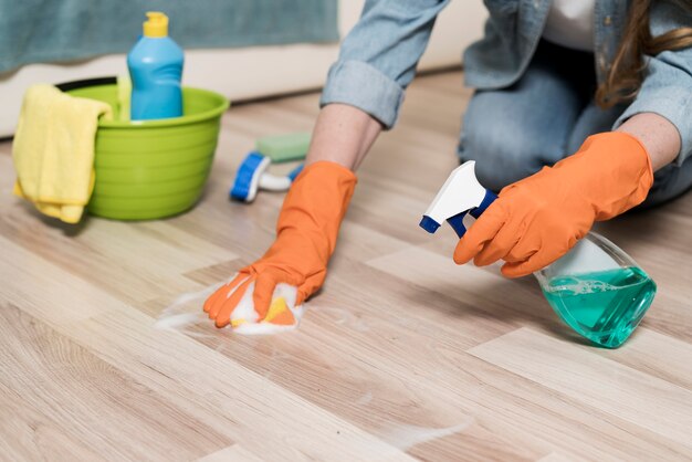 Woman with rubber gloves cleaning the floors