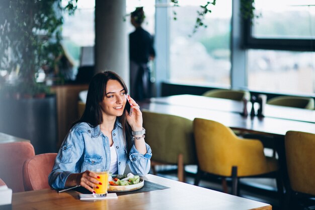 Woman with salad and phone