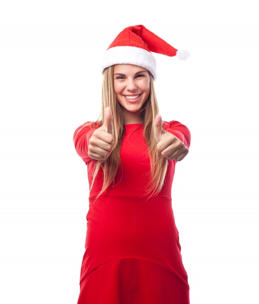 Женщина с шляпу Санта-Клауса, показывая пальцы вверх