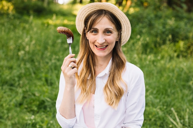 Woman with a sausage in nature