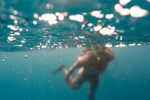 Foto gratuita donna con attrezzatura subacquea nuotare nell'oceano
