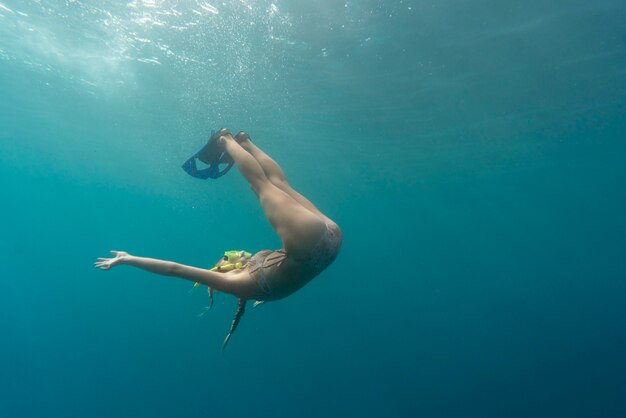 Woman with scuba gear swimming in the ocean