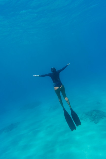 海で泳ぐスキューバギアを持つ女性