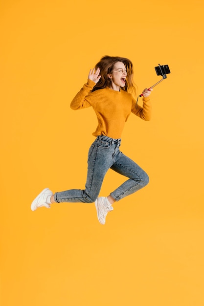 Woman with selfie stick jumping