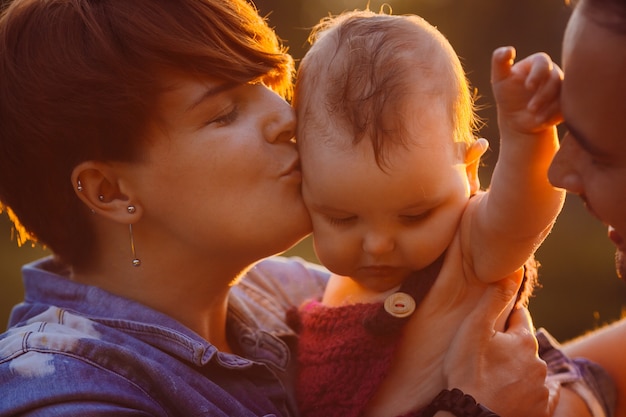 La donna con i capelli della camicia bacia la bambina