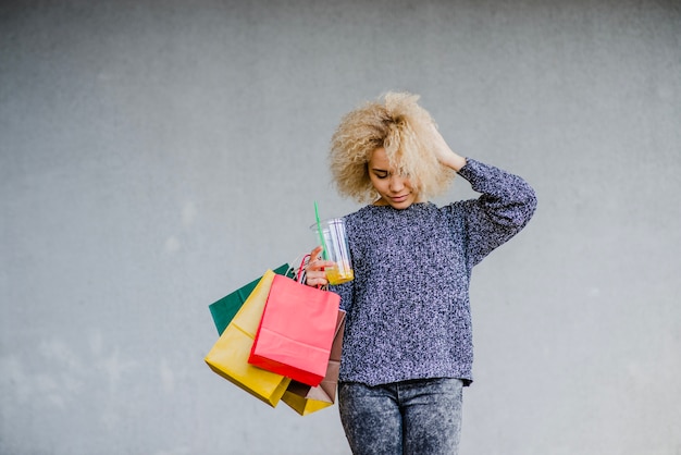 Free photo woman with shopping bags adjusting hair.