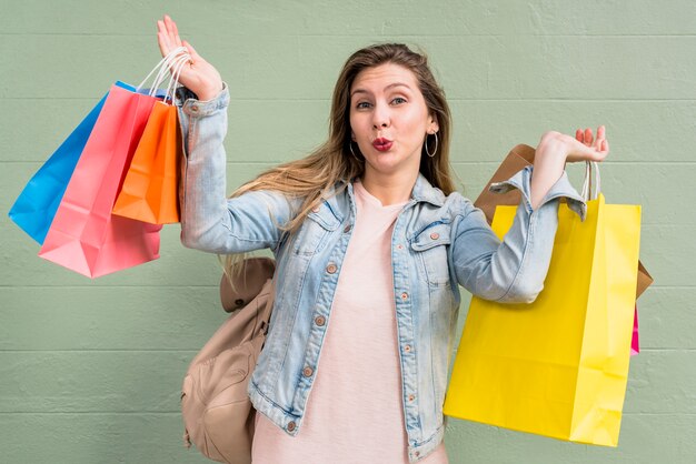 Woman with shopping bags blowing kiss 