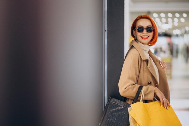 Woman with shopping bags making purchases in mall