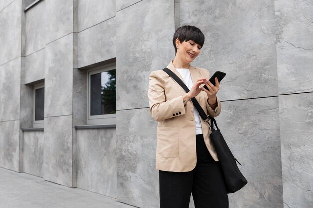 Woman with short hair checking her phone outdoors