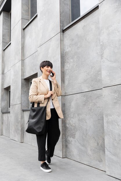 Woman with short hair talking on the phone outdoors
