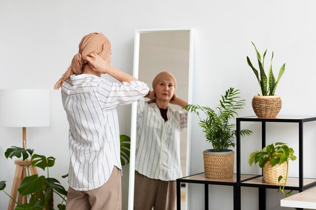 Женщина с раком кожи смотрит в зеркало