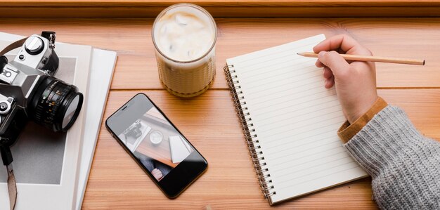 スマートフォンと一杯のコーヒーを持つ女性