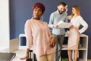 Foto gratuita donna con smartphone vicino a colleghi di lavoro