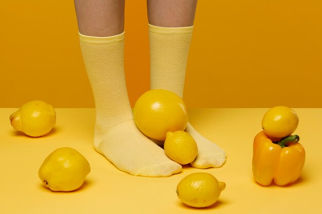 Woman with socks having fruits and vegetables at her feet