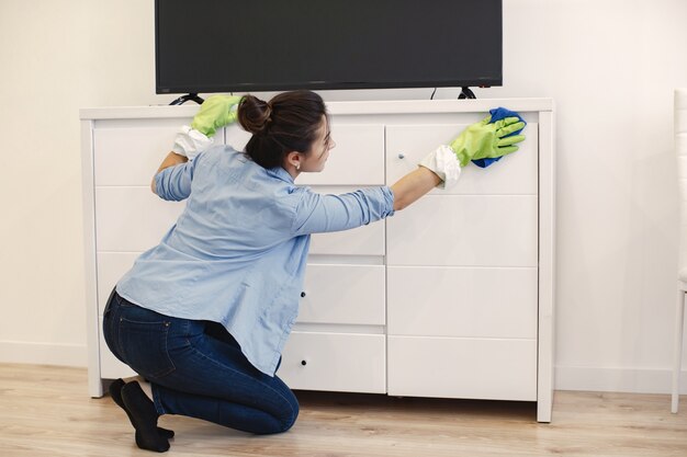 Woman with sponge and rubber gloves cleaning house