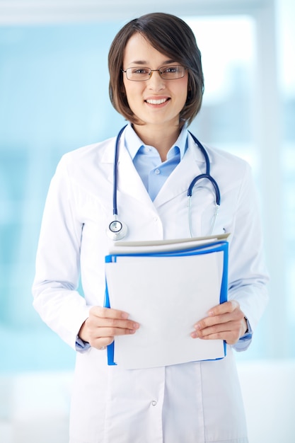 Woman with stethoscope holding a clipboard
