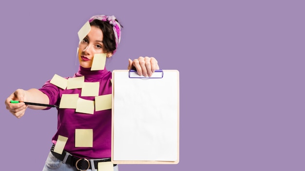 Free photo woman with sticky notes on her holding a clipboard with copy space