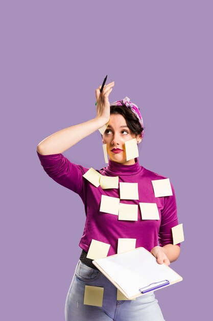 Woman with sticky notes on her holding a clipboard